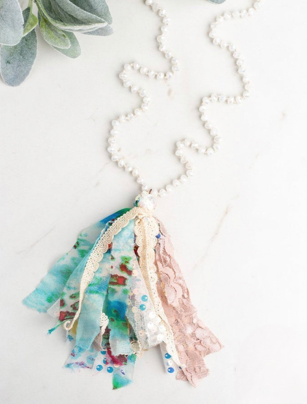 White beaded necklace with pastel tassel